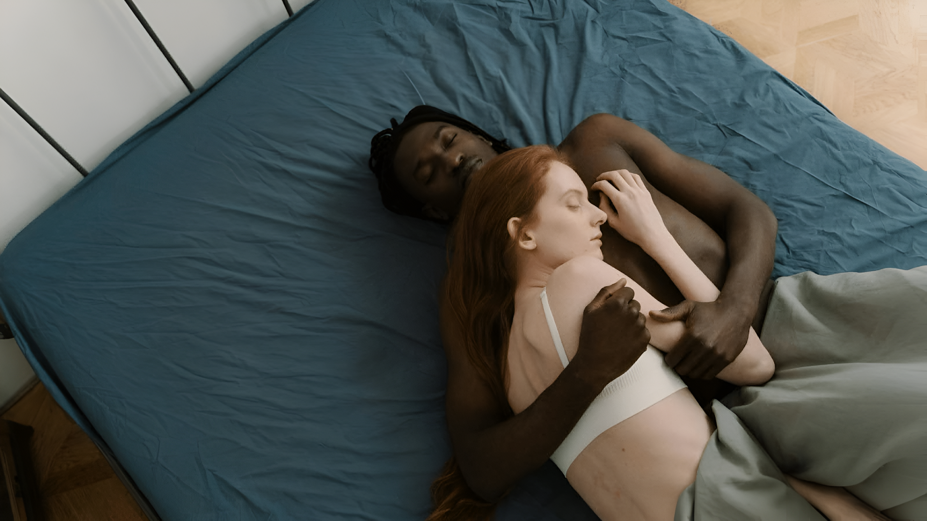 Couple sleeping closely in bed, intimate and peaceful